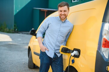 Man charges an electric car at the charging station.