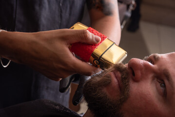 Barber shop, barber shaving his client, selective focus.
