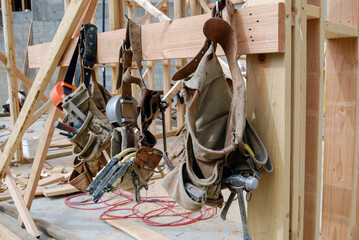 Carpenters tool bags hanging from a wood framed structure