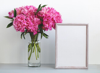 pink peonies and an empty frame on the table