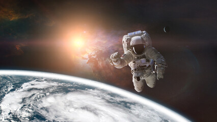 Fototapeta na wymiar Spaceman is flying in outer space on Earth background. Elements of this image furnished by NASA.
