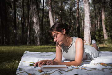 woman reading magazine in nature on a sunny day, spending time in nature self-development