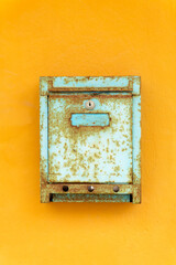 Weathered mailbox on a yellow wall - 0988