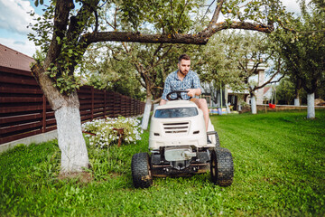 Gardener using tractor and mowing grass, cutting grass