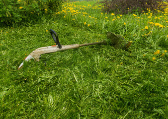 the trimmer is lying in the grass after work