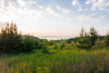 Fototapeta na wymiar Sunset over the river. Beautiful sunset on the hills of the Dnipro river. Panoramic view of the Ukrainian landscape