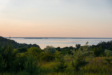 Fototapeta na wymiar Sunset over the river. Beautiful sunset on the hills of the Dnipro river. Panoramic view of the Ukrainian landscape