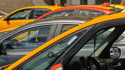 Yellow taxi cars stand in a tight traffic jam on a hot summer day