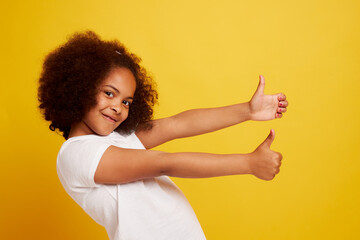 portrait of a young African girl smiling and rejoicing on a clean yellow background