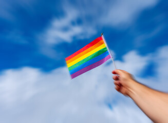 LGBT flag in hand against the sky with motion blur effect