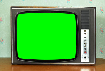 Old vintage green screen TV in a room with vintage wallpaper. Interior in the style of the 1960s.