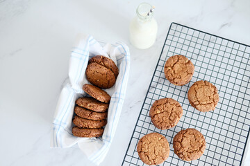 Freshly baked healthy vegan cookie on a cooling rack stand on a table next to milk. View from