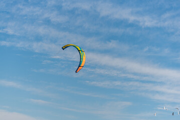 colorful kitesurfing kite with cloudy sky background