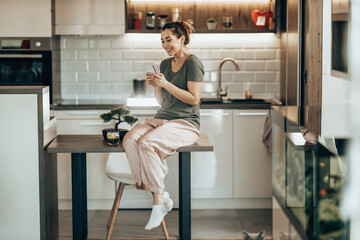Woman Using Smartphone In The Morning At Home