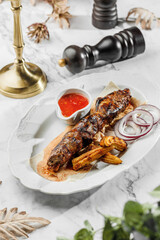 Grilled kebab meat with grilled corn with red cherry sauce ,pita and onion at the white plate on light marble background. Healthy sea food, hard light, restaurant decor, close up