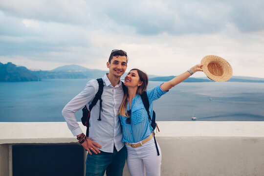 Young couple in love enjoying honeymoon on Santorini island Greece at sunset in Oia. Summer vacation traveling