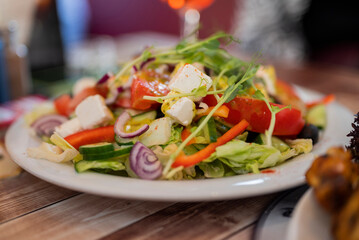 delicious vegetable salad with feta greek cheese on a plate in a restaurant close-up