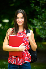 Beautiful female student holding a book outdoor