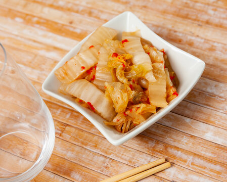 Spicy pickled napa cabbage kimchi with minced habanero in salad bowl. Typical Korean vegetable side dish..