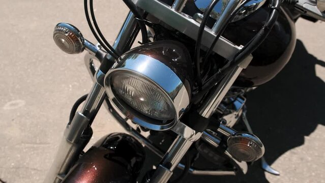 Close up view of motorcycle headlight. Chopper or dragster is parked on road. Photographing motorbike parts.