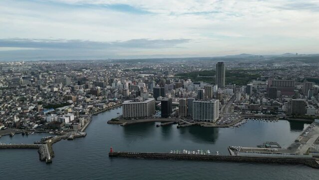 Slow aerial move toward harbor and buildings in central Akashi
