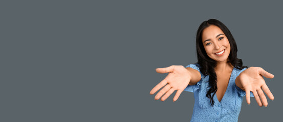 Happy young Asian woman on grey background with space for text