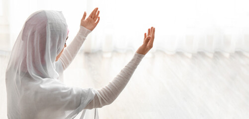 Young Muslim woman praying at home