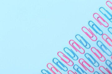 Pink and blue paper clips on color background
