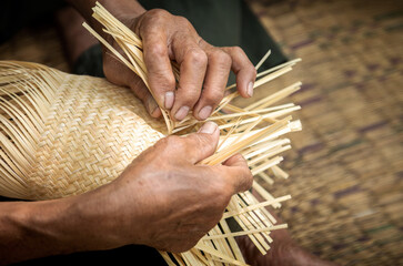 Close up of elderly hands manually weaving bamboo basket, handicraft traditional, basketweave