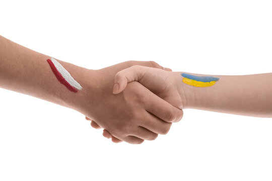 Volunteers with drawn flags of Ukraine and Poland shaking hands on white background