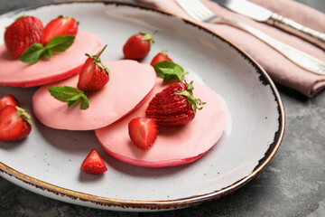 Plate of tasty pancakes with strawberry on grunge background, closeup