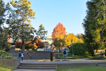 Unrecognizable students walking on the campus of University of Talca (Chile) during autumn sunny afternoon