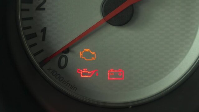 The warning lights on the car dashboard come on. Close-up.
