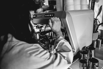 Barista woman making coffee on a vintage coffee machine and coffee barista tools and jugs over a...
