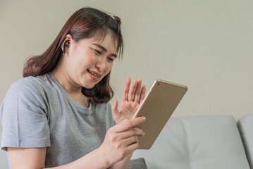 woman use tablet and ear phone watching social cam