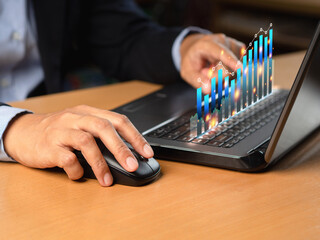 Business person analyzing financial report on a virtual screen while sitting at a desk in the office