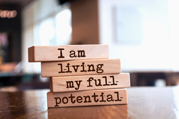 Wooden blocks with words 'I am living my full potential'.
