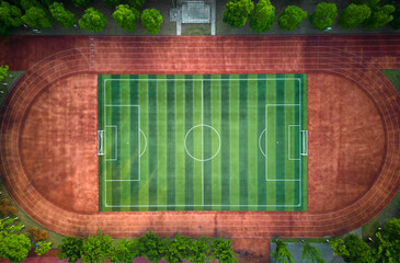 Top view of a soccer field in the public park, trees around the stadium. Aerial view. © Dusan