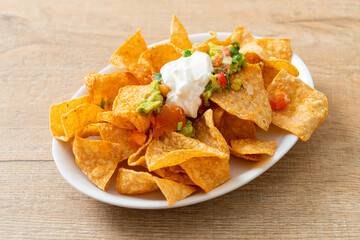 nachos tortilla chips with jalapeno, guacamole, tomatoes salsa and dip