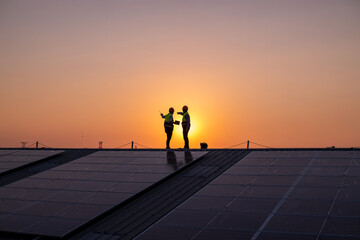 Engineers walking on roof inspect and check solar cell panel by hold equipment box and radio...