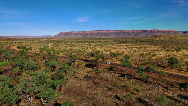 Aerial panning footage of a camper van traveling across beautiful El Questro, Kimberley, Kununurra, Western Australia