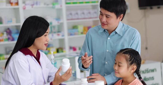 Asian Female pharmacist talking and giving medicine to asian customer in pharmacy store 4k video