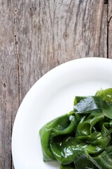 Wakame seaweed on wood background