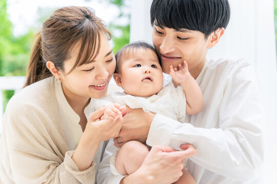 笑顔の赤ちゃんと両親　子育てイメージ