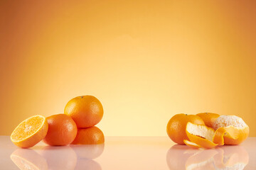 Front view of orange decorated with glassware and transparent podium in brown background