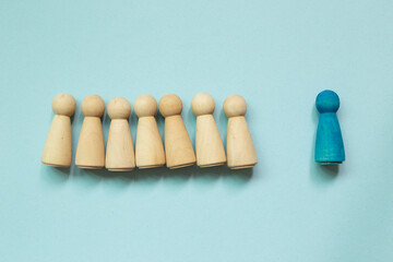 Majority vs minority concept. Wooden human figure on blue background