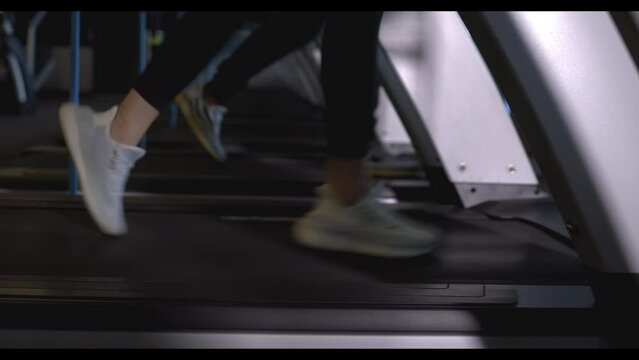 Closeup of legs woman jogging on treadmill in gym, 4k video