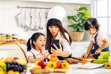 Portrait of enjoy happy love asian family mother and little asian girl daughter child having fun help cooking food healthy eat together with fresh vegetable salad and sandwich ingredient in kitchen