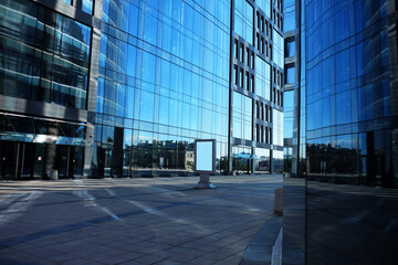 Fototapeta na wymiar Offices building exterior in summer sunny day. Blue sky had been reflected in the glass of windows.