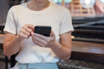 Casual Businesswoman holding and using smartphone for sms messages, young woman typing touchscreen mobile phone in cafe or modern office. lifestyle, technology, Social media and network concept